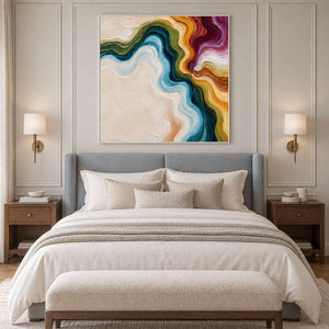 White-framed abstract above a gray headboard with pale bedding and matching bedside lights.