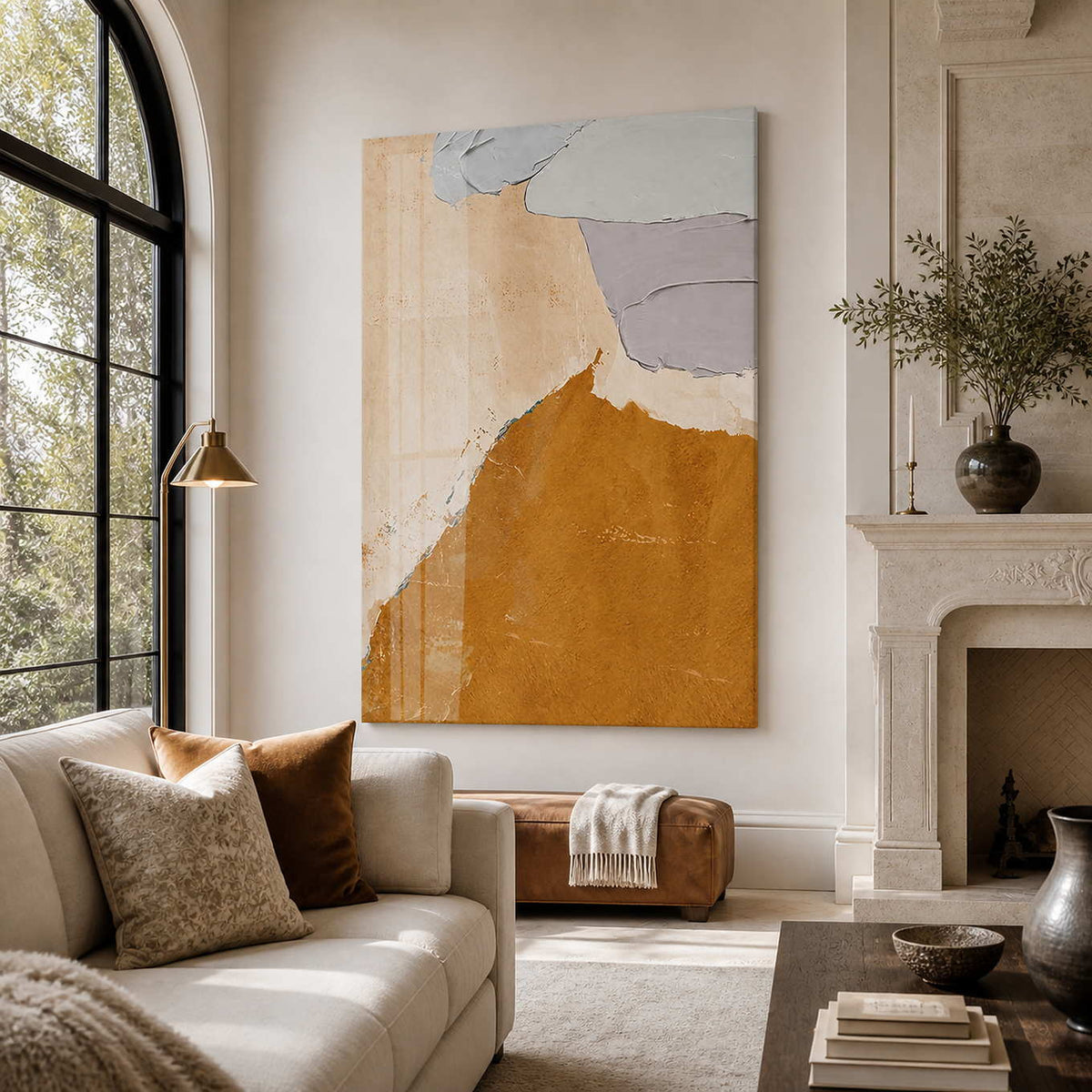 Frameless ochre and beige abstract artwork beside an arched window in a bright living room.