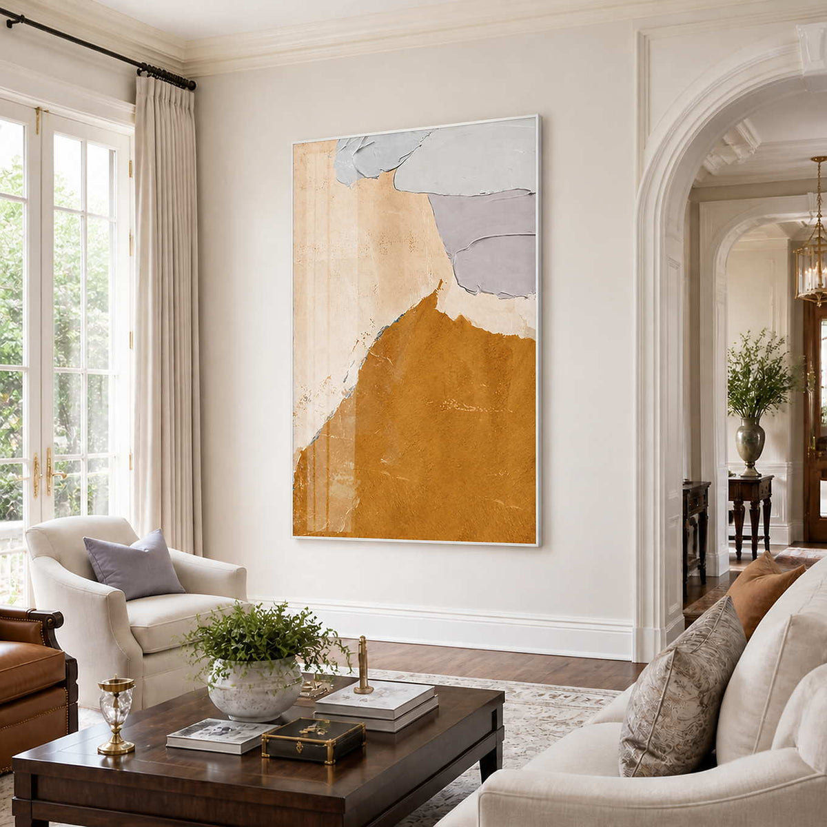 White framed ochre and gray abstract artwork above cream seating in an airy sitting room.