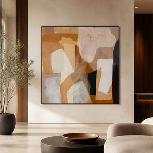 Square earth-tone artwork facing lounge seating beside a tall potted tree.