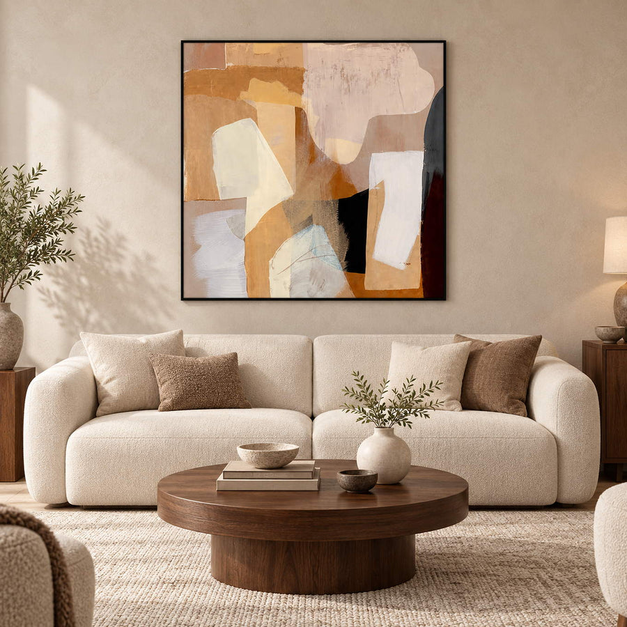 Warm geometric abstract painting over a cream sofa and round wooden coffee table.