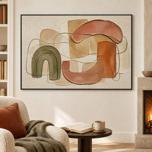 Boho abstract painting with olive, terracotta, blush, and sand arches in a black frame in a seating area beside a fireplace.