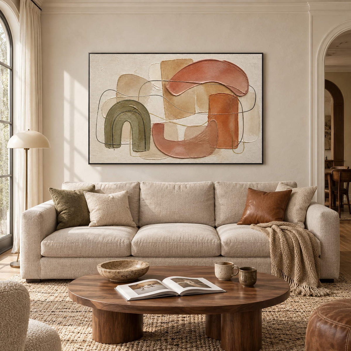 Boho abstract painting with olive, terracotta, blush, and sand arches in a black frame in a living room.
