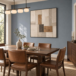 Textured ivory stone caramel and charcoal blocks in a quiet square composition, displayed in a dining room in a black frame.