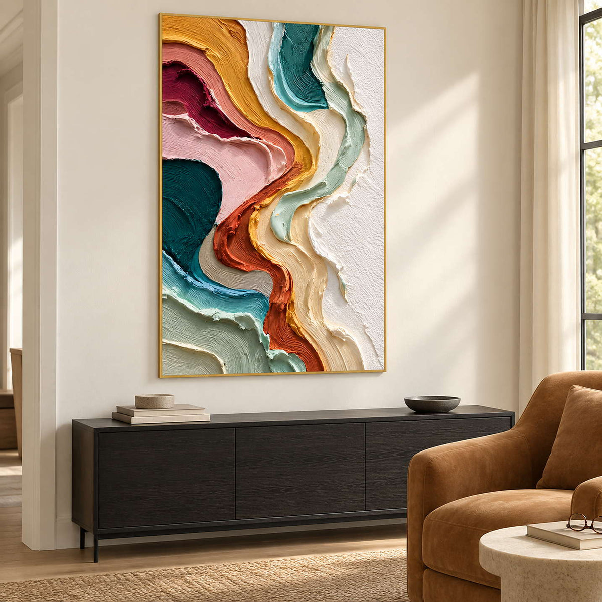 Gold-toned framed abstract beside a brown armchair and dark cabinet.