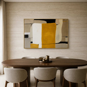 Gold framed ochre and cream abstract artwork above an oval wooden dining table.