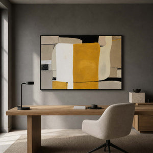 Black framed ochre and white abstract painting above a wooden office desk.