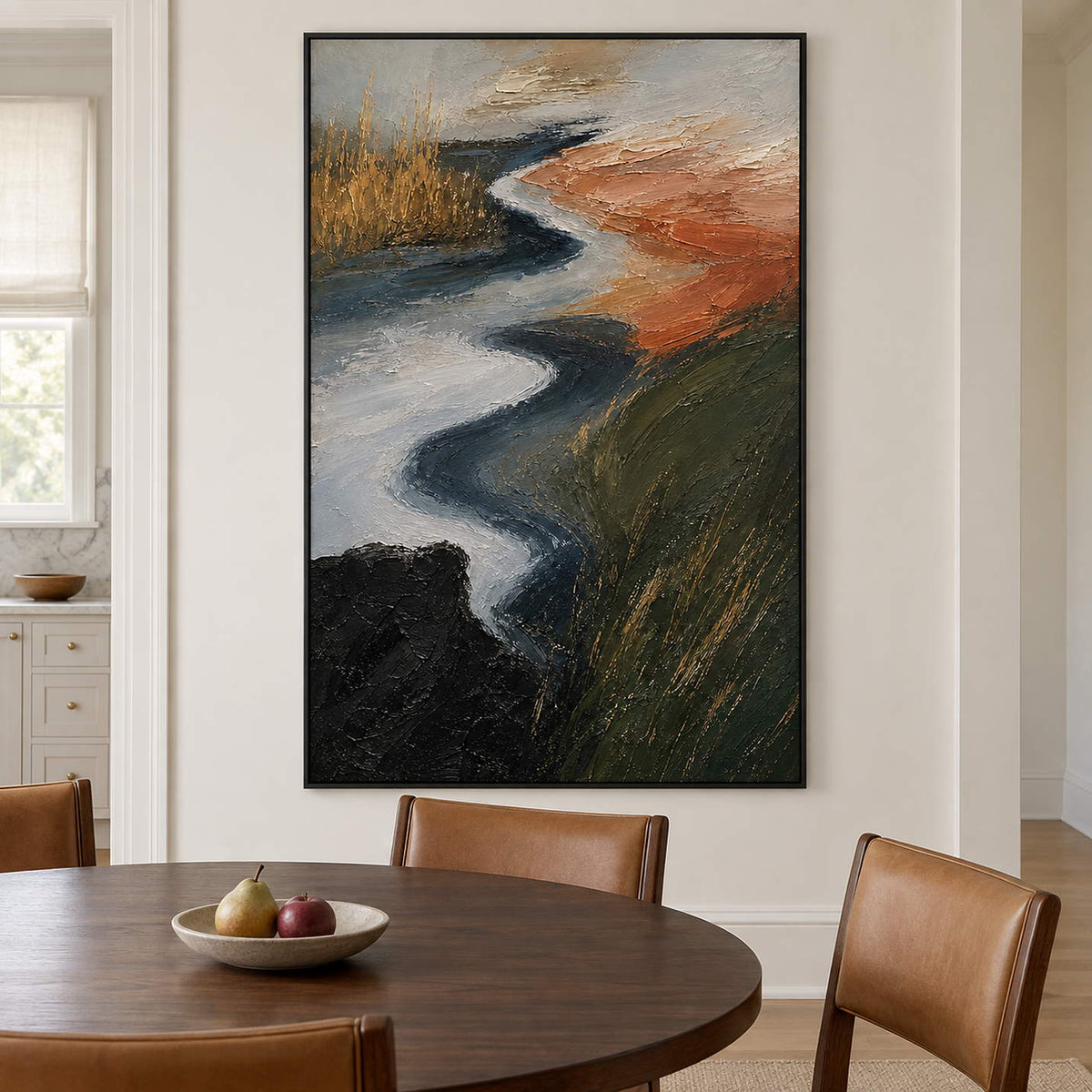 A winding pale waterway between dark green and rust-colored fields in a black frame, displayed above a dining table.