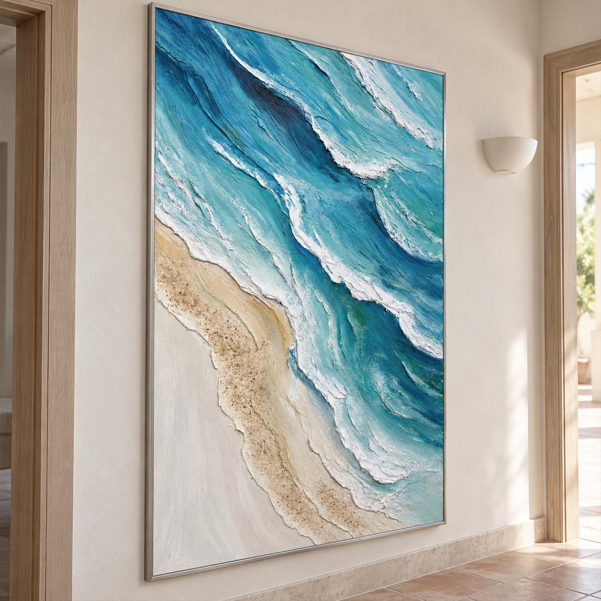Artwork showing layered blue-green waves with raised white edges beside a pale sandy shore in a hallway above a bench, with a silver-colored frame.