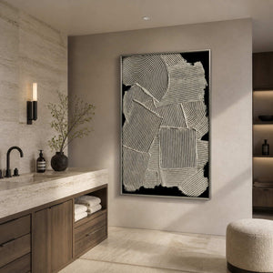 Silver framed ribbed abstract artwork beside a pale stone vanity in a bathroom dry area.
