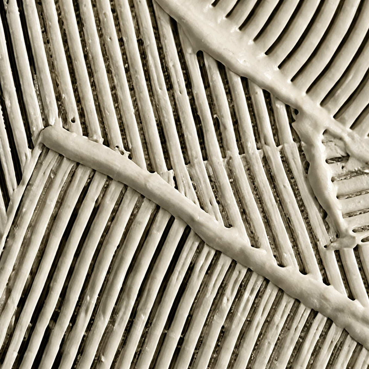 Macro view of raised cream ridges meeting at different angles with dark recessed grooves.