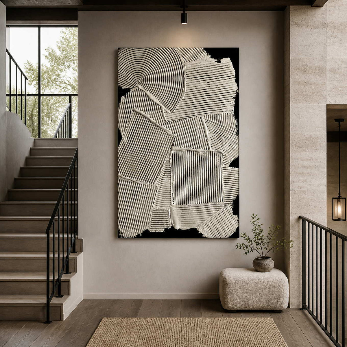 Frameless cream and black abstract artwork displayed beside a staircase in a bright residential hall.