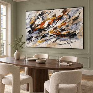 Hand-painted abstract artwork with black gestures and rust, ochre, ivory, and gray layers, displayed in a dining room in a black frame.