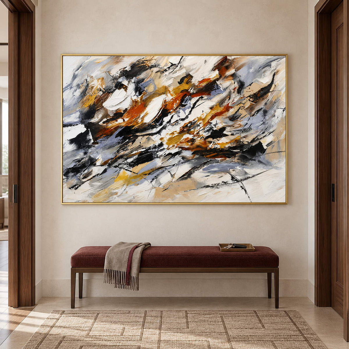 Hand-painted abstract artwork with black gestures and rust, ochre, ivory, and gray layers, displayed in a hallway in a gold frame.