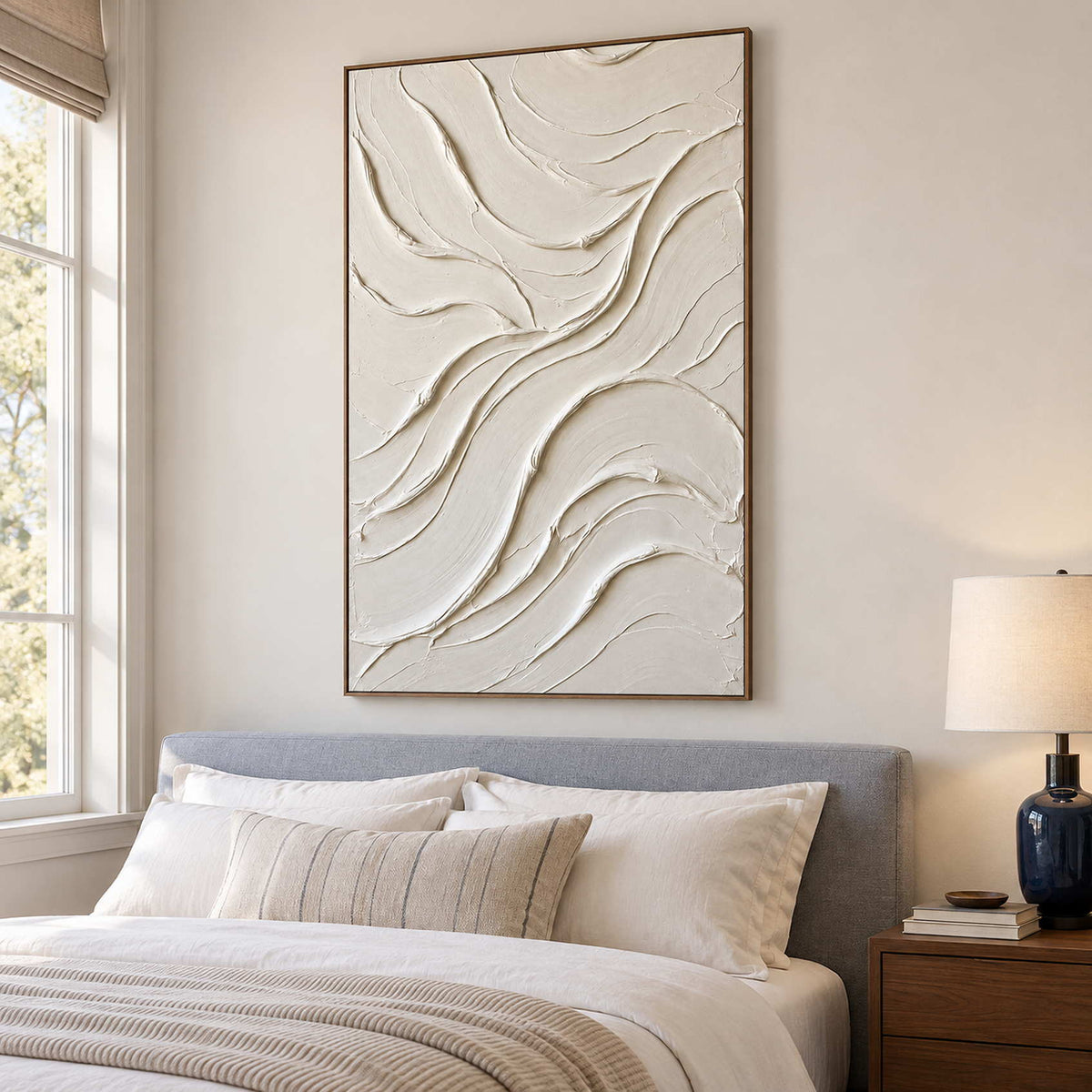 Soft ivory artwork above a pale upholstered bed.