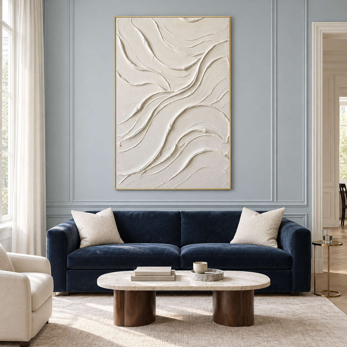 Ivory wave-texture artwork above a navy sofa on a paneled wall.