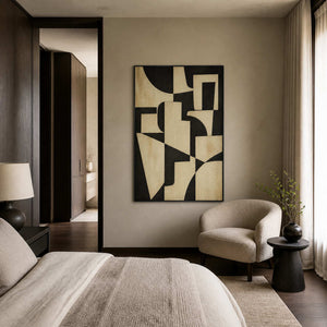 Black and ivory abstract painting displayed in a gray-beige bedroom.