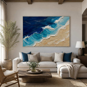 Turquoise ocean artwork displayed above a relaxed cream living room sofa.