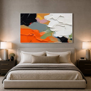 Layered orange and black abstract canvas above a serene neutral bedroom.