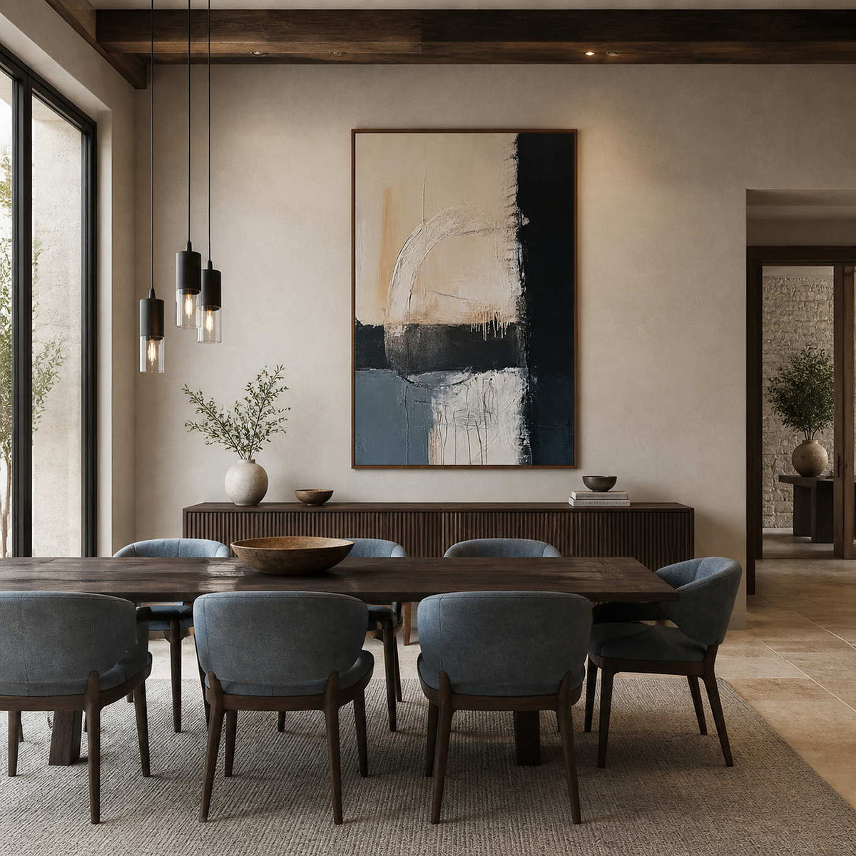 Wood-framed Where Day Meets Night above a sideboard behind a dining table with blue upholstered chairs.