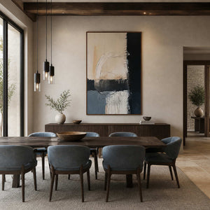Wood-framed Where Day Meets Night above a sideboard behind a dining table with blue upholstered chairs.