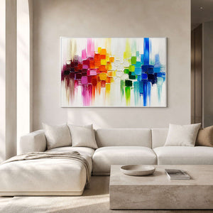 Colorful textured abstract wall art displayed above a soft white living room sofa.