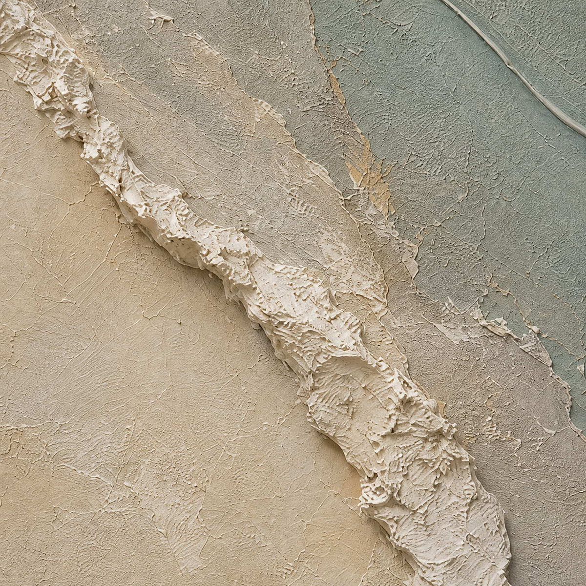 Close-up of raised white texture sage paint cream layers and gold seams.