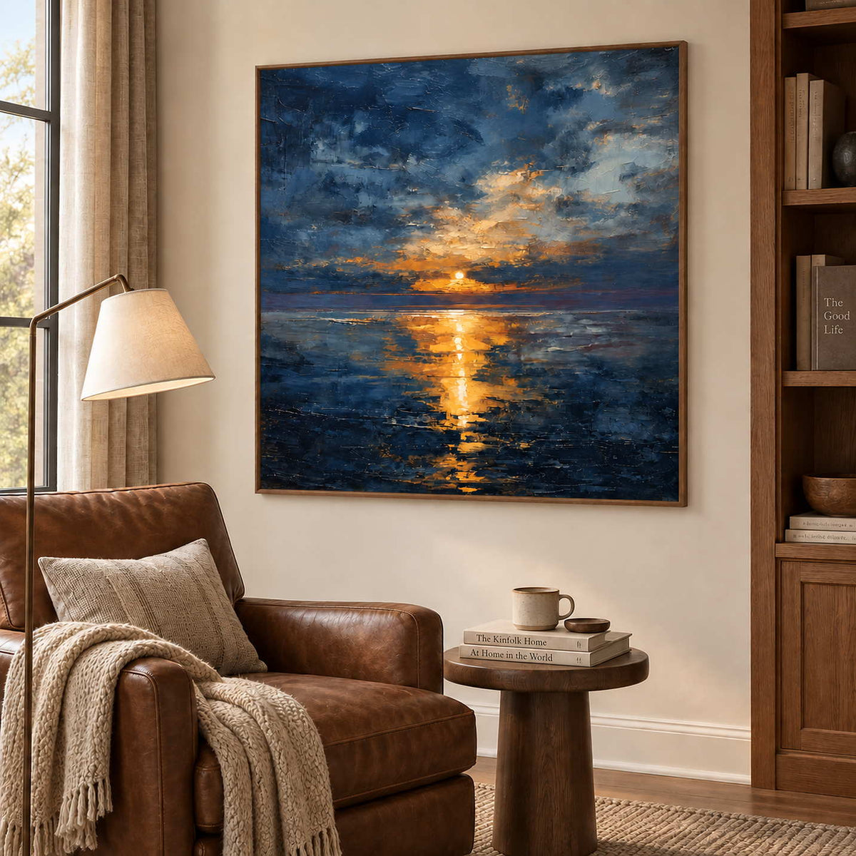 Sea reflection artwork beside a brown leather reading chair and small round side table.