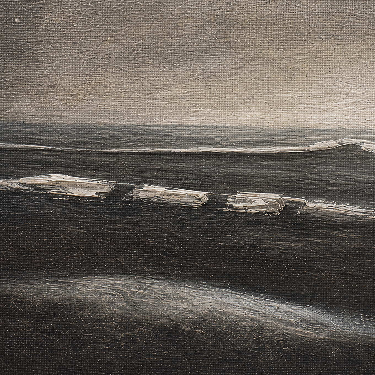 Close-up of charcoal shoreline ivory surf and layered gray texture.