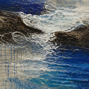 Close-up of raised white surf, dark rock, and cobalt blue texture.