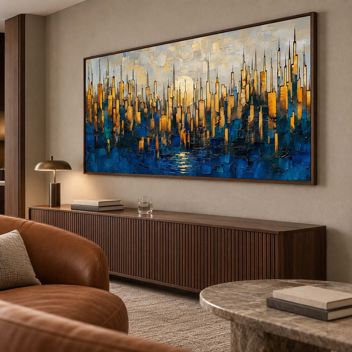 Wide city painting above a ribbed dark wood cabinet beside brown leather seating.