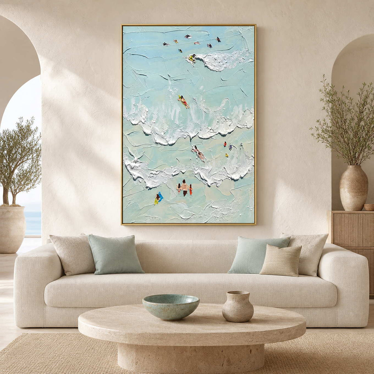 Sea-glass coastal wall art above a softly curved neutral living room sofa.