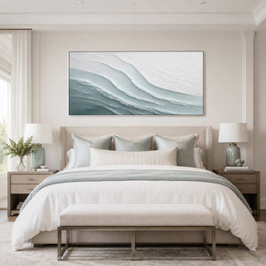 Panoramic coastal wall art above a calm neutral bedroom