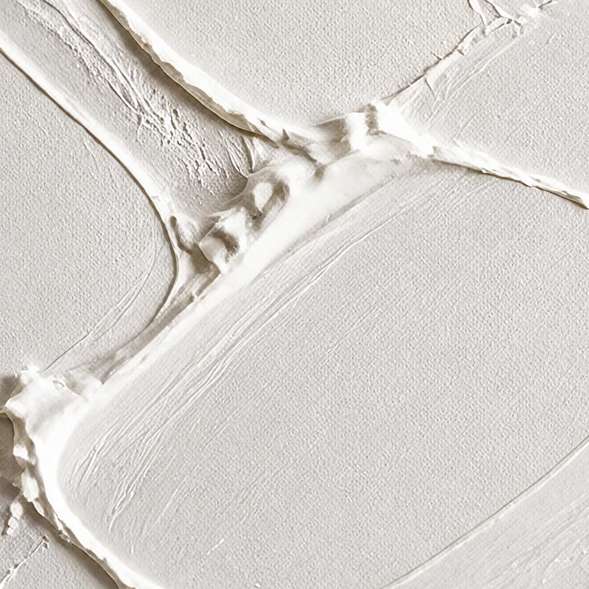 Close-up of raised irregular seams and layered chalk white paint texture.