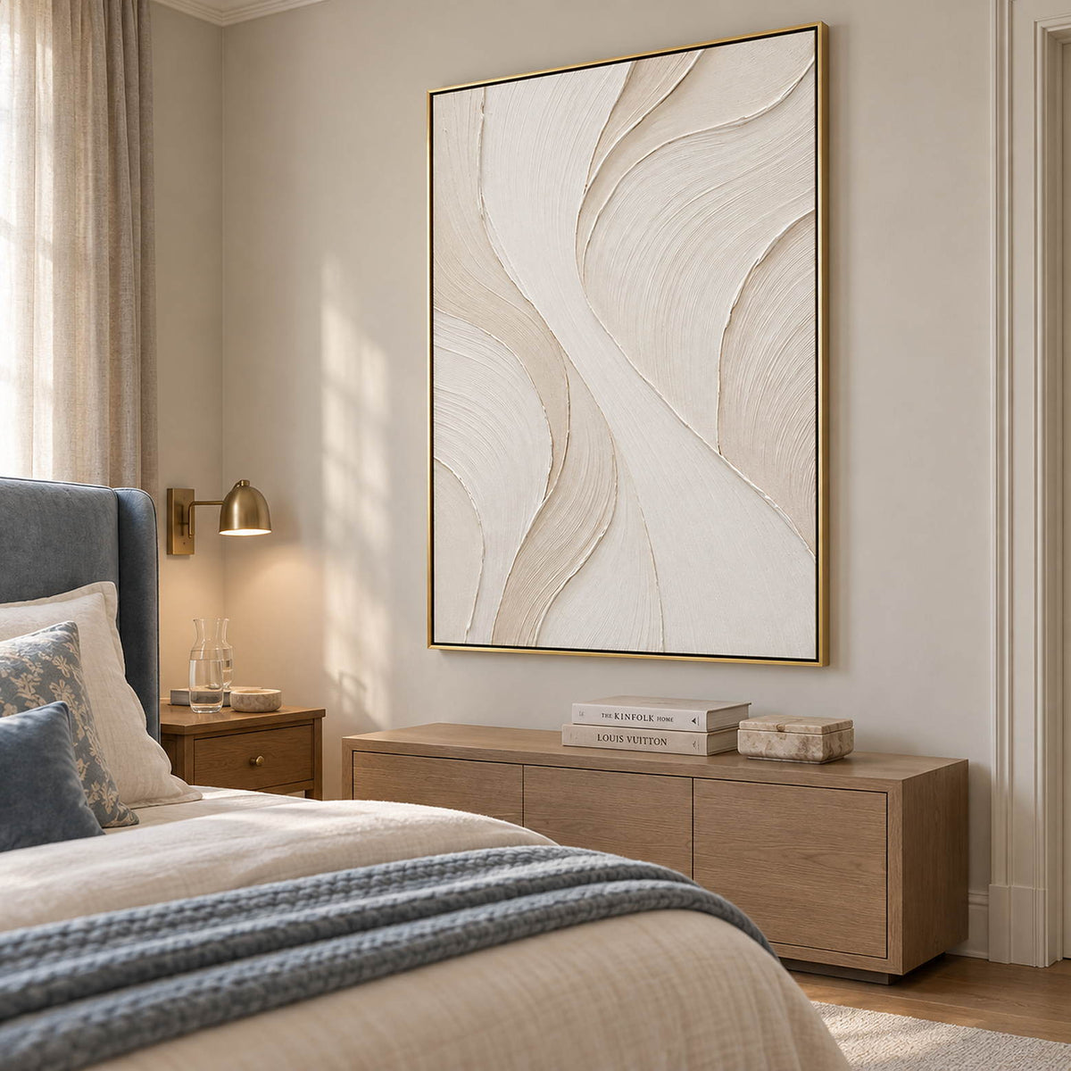 Hand-painted ivory abstract wall art with flowing cream relief and fine combed texture, displayed in a bedroom in a gold frame.