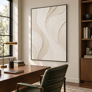 Hand-painted ivory abstract wall art with flowing cream relief and fine combed texture, displayed in a study in a black frame.