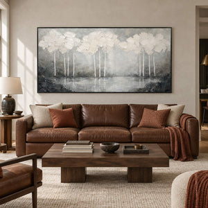 Hand-painted textured landscape wall art in white, pearl gray, and charcoal, displayed in a living room in a black frame.