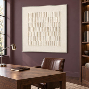 Square ivory relief artwork formed by rows of raised vertical marks, displayed in a study in a silver frame.