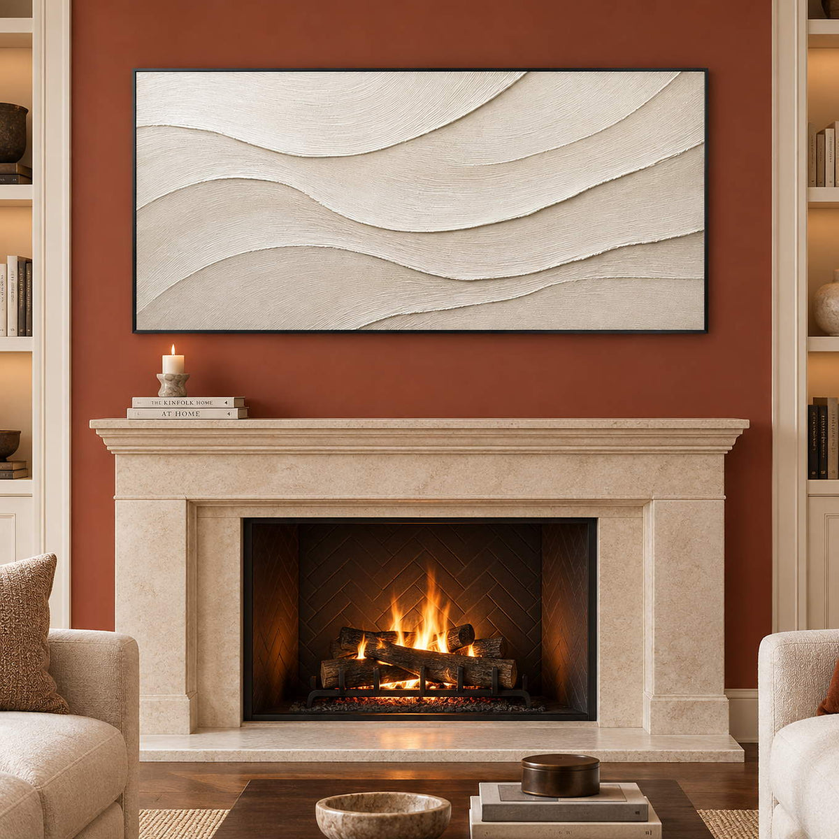 Layered ivory and warm beige relief flowing in quiet panoramic waves, displayed beside or above a fireplace in a black frame.