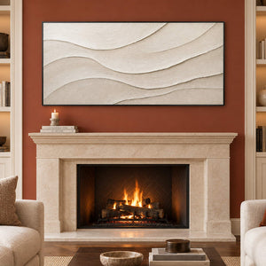 Layered ivory and warm beige relief flowing in quiet panoramic waves, displayed beside or above a fireplace in a black frame.