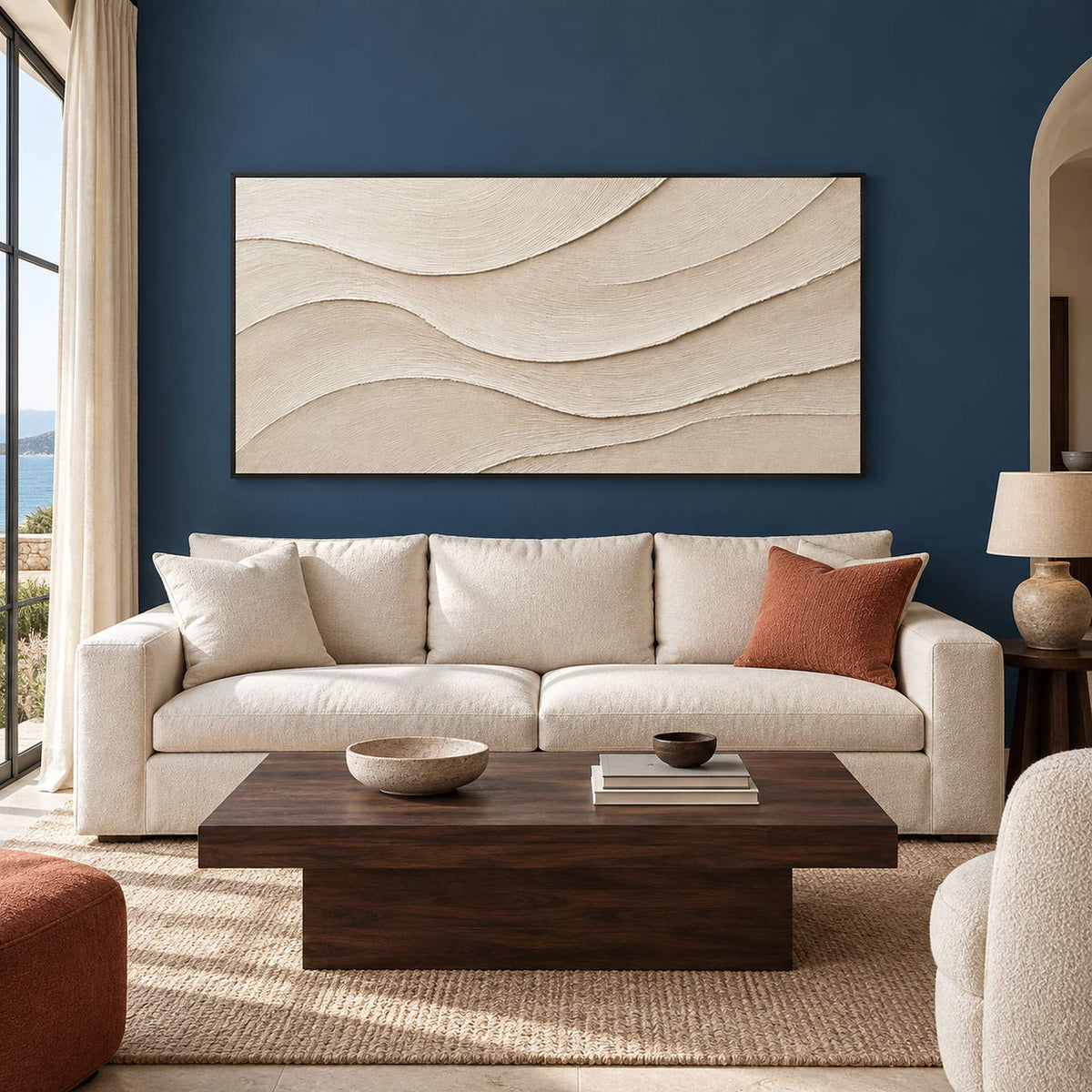 Layered ivory and warm beige relief flowing in quiet panoramic waves, displayed in a living room in a black frame.