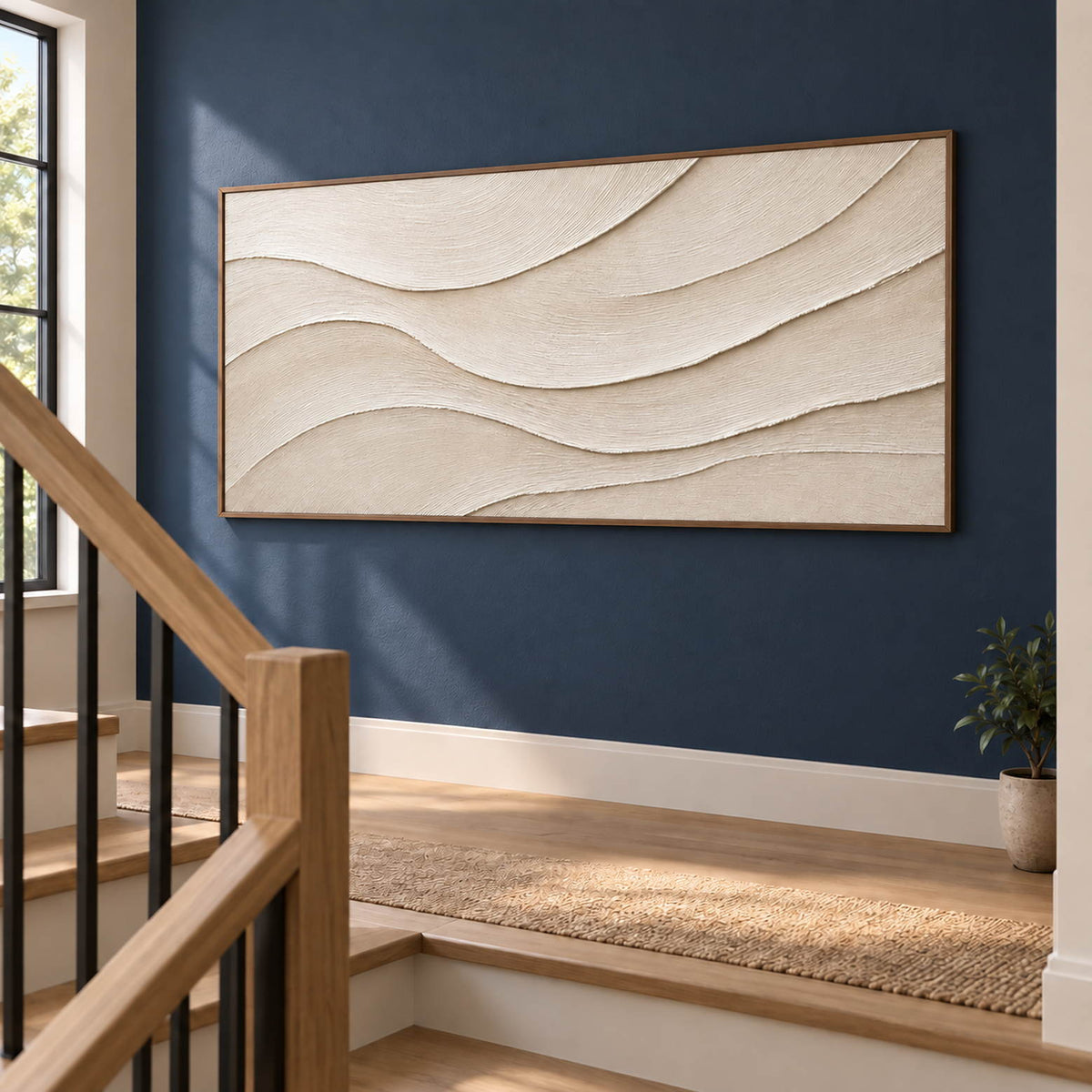 Layered ivory and warm beige relief flowing in quiet panoramic waves, displayed beside a staircase in a brown wood frame.