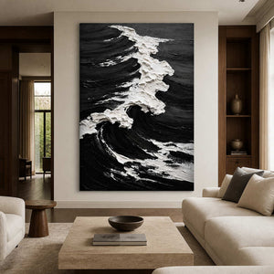 Frameless black and white coastal artwork with a breaking wave beside living room seating.