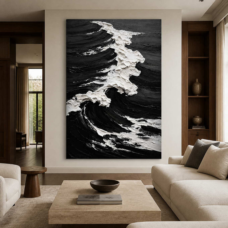 Frameless black and white coastal artwork with a breaking wave beside living room seating.