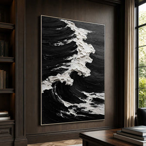 Silver framed black and white wave artwork on a dark home office wall.