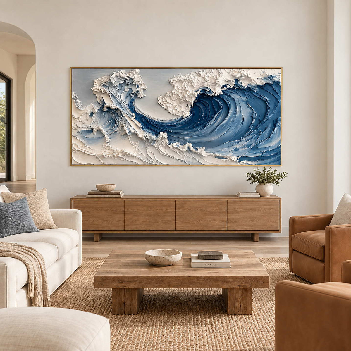Blue and white wave painting above a wood sideboard in a neutral living room.