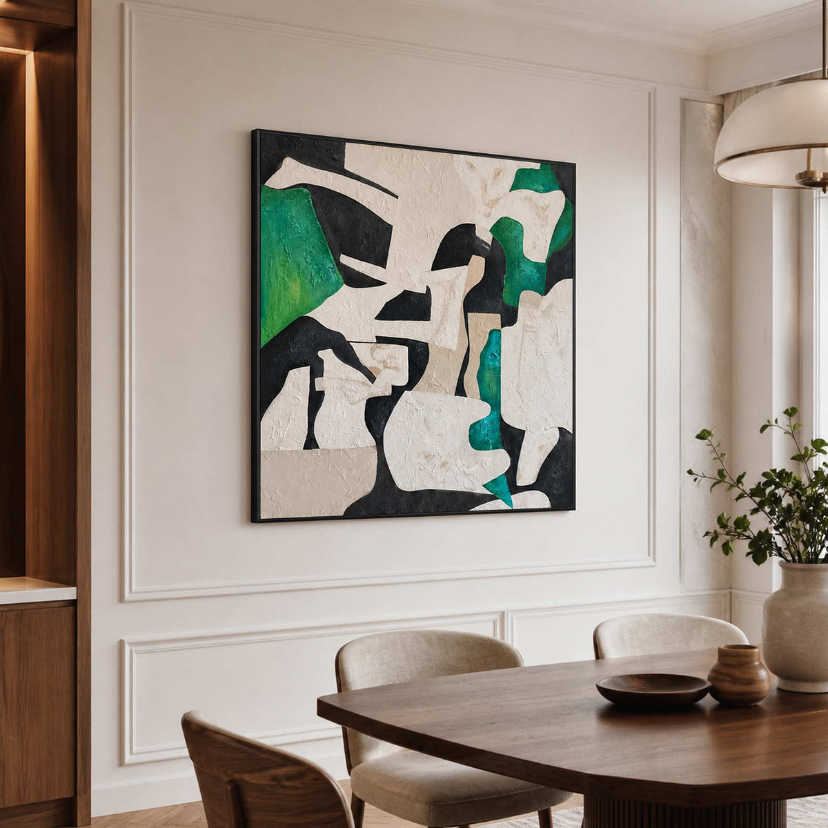 Black framed green and cream abstract artwork above a wooden dining table.