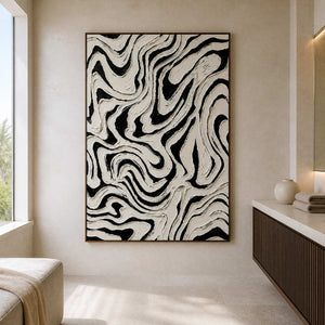 Wood framed black and white abstract artwork with flowing ridges beside a bathroom vanity.