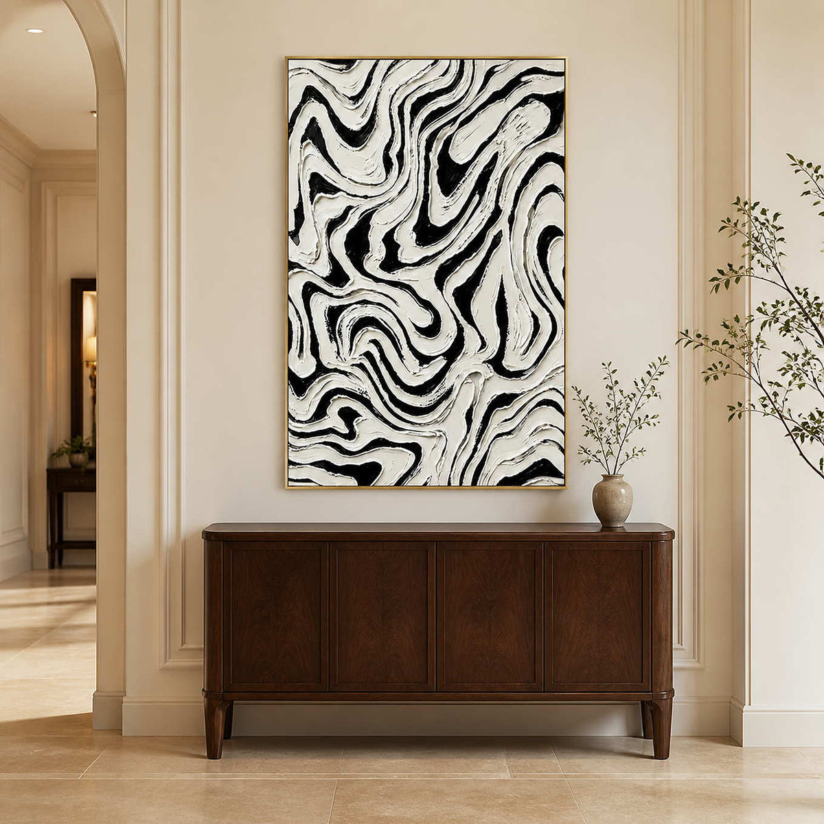 Gold framed abstract painting with bold black channels above a wooden hallway cabinet.
