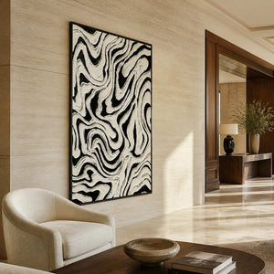 Black framed vertical abstract artwork with undulating white lines in a hotel lounge.